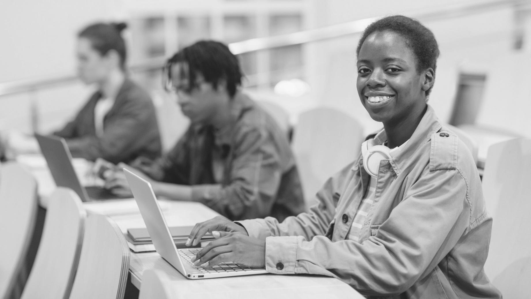 Studierende analysieren Wirtschaftsdaten am Laptop
